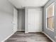 Bedroom with wood-look floors, closet, and window offers simple yet functional living space at 7472 E Paraiso Dr, Scottsdale, AZ 85255