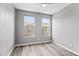 Bedroom with wood-look floors and two windows showcasing exterior buildings and ample natural light at 7472 E Paraiso Dr, Scottsdale, AZ 85255
