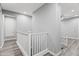 Upstairs hallway with wood floors, white railings and baseboards, and neutral gray walls at 7472 E Paraiso Dr, Scottsdale, AZ 85255