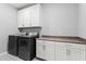 Laundry room showcasing a modern washer and dryer set next to built-in cabinetry with countertops at 7472 E Paraiso Dr, Scottsdale, AZ 85255