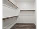Spacious walk-in closet features built-in shelving and wood floors at 7472 E Paraiso Dr, Scottsdale, AZ 85255