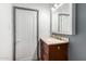 A bathroom featuring a single sink vanity with a medicine cabinet and a white door at 8132 E 3Rd Ave, Mesa, AZ 85208