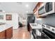 Galley kitchen with wood cabinets and stainless steel appliances at 8132 E 3Rd Ave, Mesa, AZ 85208