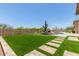 Expansive backyard featuring lush artificial turf, a serene pool, and a stylish stone walkway at 8725 E Menlo Cir, Mesa, AZ 85207