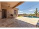 Inviting backyard with a covered patio, outdoor seating, a sparkling pool, and lush landscaping, perfect for relaxation at 8725 E Menlo Cir, Mesa, AZ 85207