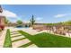 Spacious backyard featuring a pool, fire pit, outdoor seating, and lush landscaping, perfect for entertaining and relaxation at 8725 E Menlo Cir, Mesa, AZ 85207