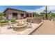 Inviting backyard with a fire pit, desert landscaping, and built-in seating, perfect for outdoor entertaining at 8725 E Menlo Cir, Mesa, AZ 85207