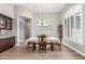 Bright dining area featuring a decorative light fixture, hardwood floors, and a buffet with granite countertop at 8725 E Menlo Cir, Mesa, AZ 85207