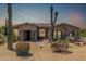 Inviting single-story home featuring desert landscaping, including saguaro cacti, and a charming front porch at 8725 E Menlo Cir, Mesa, AZ 85207