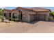 Attractive single-story house featuring a paver driveway, three-car garage and low maintenance desert landscaping at 8725 E Menlo Cir, Mesa, AZ 85207