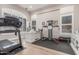 Bright home gym with ample natural light, modern exercise equipment, and a built-in desk for productivity at 8725 E Menlo Cir, Mesa, AZ 85207