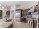 Stylish kitchen featuring stainless steel appliances and a granite island with bar stool seating at 8725 E Menlo Cir, Mesa, AZ 85207
