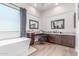 Luxurious main bathroom featuring a soaking tub, dual vanities, and a large window at 8725 E Menlo Cir, Mesa, AZ 85207