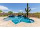 Inviting pool and spa with desert landscaping, a relaxing waterfall feature, and a spacious travertine deck for lounging at 8725 E Menlo Cir, Mesa, AZ 85207