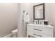 Elegant powder room with white vanity, framed mirror, modern faucet, and toilet at 8725 E Menlo Cir, Mesa, AZ 85207