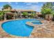 Resort-style pool area surrounded by lush landscaping, lounge chairs, and community seating at 9451 E Becker Ln # 1051, Scottsdale, AZ 85260