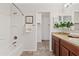 Bright bathroom features a tub, shower, single sink vanity with a view through to a walk-in closet at 973 E Kelsi Ave, San Tan Valley, AZ 85140