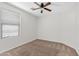 Neutral bedroom featuring a large window offering natural light, carpet flooring, and ceiling fan at 973 E Kelsi Ave, San Tan Valley, AZ 85140