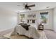 Bedroom features a ceiling fan, two windows that allow natural light, and a comfortable bed at 973 E Kelsi Ave, San Tan Valley, AZ 85140