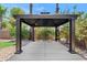 The gazebo features a concrete slab and a black metal frame with tropical landscaping surrounding the structure at 973 E Kelsi Ave, San Tan Valley, AZ 85140