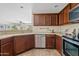 Well-lit kitchen features stainless steel appliances, tile floors, and beautiful wood cabinets at 973 E Kelsi Ave, San Tan Valley, AZ 85140