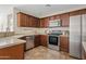 Kitchen with stainless steel appliances, wood cabinets, and tile flooring at 973 E Kelsi Ave, San Tan Valley, AZ 85140