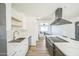 Stylish kitchen with white cabinets, stainless steel appliances, open shelving, and a view into the living room at 1017 E Diana Ave, Phoenix, AZ 85020