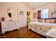 Comfortable bedroom featuring a walk-in closet, light pink paint, and wooden floors at 11022 N 60Th Dr, Glendale, AZ 85304