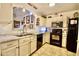 Well-lit kitchen features white cabinets, black appliances, and modern countertops at 11022 N 60Th Dr, Glendale, AZ 85304
