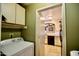 The laundry room has green walls and opens to the kitchen at 11022 N 60Th Dr, Glendale, AZ 85304