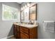 Bathroom with a double sink vanity, granite countertops, wood cabinets, and light fixtures above the mirrors at 1134 W 2Nd St, Mesa, AZ 85201