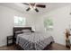 Cozy bedroom featuring a comfortable bed with a patterned duvet, two windows, and a ceiling fan at 1134 W 2Nd St, Mesa, AZ 85201