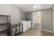 Spacious laundry room with washer, dryer, storage shelf, and view into the next room at 1134 W 2Nd St, Mesa, AZ 85201