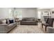 Comfortable living room with two sofas, wood-style flooring, and bright natural light from large windows at 1134 W 2Nd St, Mesa, AZ 85201