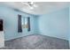 Light blue bedroom featuring soft carpeting, ceiling fan, and a bright window view at 12422 W Rosewood Dr, El Mirage, AZ 85335