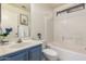 Well-lit bathroom features a blue vanity and a shower-tub combination at 13241 W Desert Ln, Surprise, AZ 85374