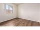 Empty bedroom with hardwood floors, white walls and a window at 13241 W Desert Ln, Surprise, AZ 85374