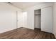 Empty bedroom featuring hardwood floors and a closet with sliding doors at 13241 W Desert Ln, Surprise, AZ 85374
