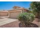 Exterior shot of a single-story home with a two-car garage, well-maintained landscaping, and a beige exterior at 13241 W Desert Ln, Surprise, AZ 85374