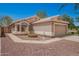 Charming single-story home featuring a tan exterior, well-maintained landscaping, and a two-car garage in a sunny setting at 13241 W Desert Ln, Surprise, AZ 85374