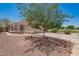 Well-kept single-story home featuring desert landscaping, a two-car garage, and a shade tree at 13241 W Desert Ln, Surprise, AZ 85374