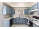 Updated kitchen boasts stylish blue cabinets, stainless steel sink, modern appliances, and bright countertops at 13241 W Desert Ln, Surprise, AZ 85374