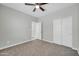 Neutral bedroom with carpet, ceiling fan, a view into bathroom, and large closet at 14178 S Diablo Rd, Arizona City, AZ 85123