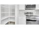 A modern kitchen featuring white cabinets, stainless steel appliances, and a walk-in pantry for optimal storage at 14178 S Diablo Rd, Arizona City, AZ 85123