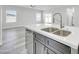 A modern kitchen island featuring a stainless steel sink, quartz countertops, and views into the living space at 14178 S Diablo Rd, Arizona City, AZ 85123