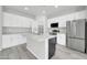Bright kitchen features white cabinets, a stainless steel refrigerator, and an island with a sink and countertop at 14178 S Diablo Rd, Arizona City, AZ 85123