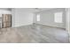 A spacious living room featuring wood-look tile flooring, neutral paint, a ceiling fan, and natural light from windows at 14178 S Diablo Rd, Arizona City, AZ 85123