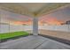 A covered patio featuring a concrete surface, artificial turf, and gravel, enclosed by a block fence with a sunset sky at 14178 S Diablo Rd, Arizona City, AZ 85123