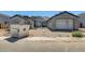 Exterior view of home under construction featuring scaffolding, tan gravel yard, and cinderblock foundation at 14687 N 73Rd Dr, Peoria, AZ 85381