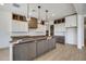 Stylish kitchen featuring a large island, custom cabinets, and modern lighting at 14687 N 73Rd Dr, Peoria, AZ 85381